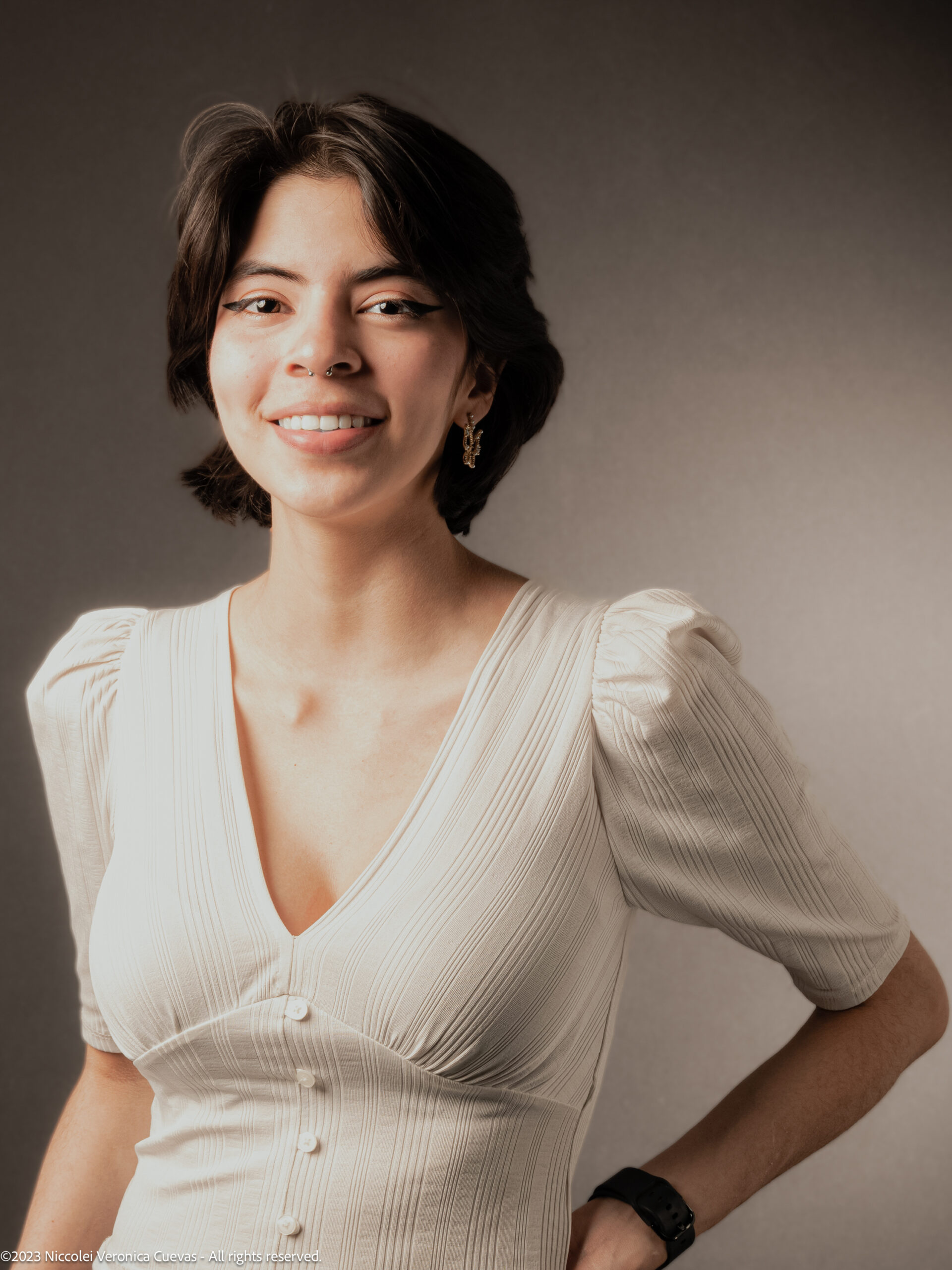 beautiful lady with short hair and wearing white shirt, posing and smiling to the camera camera