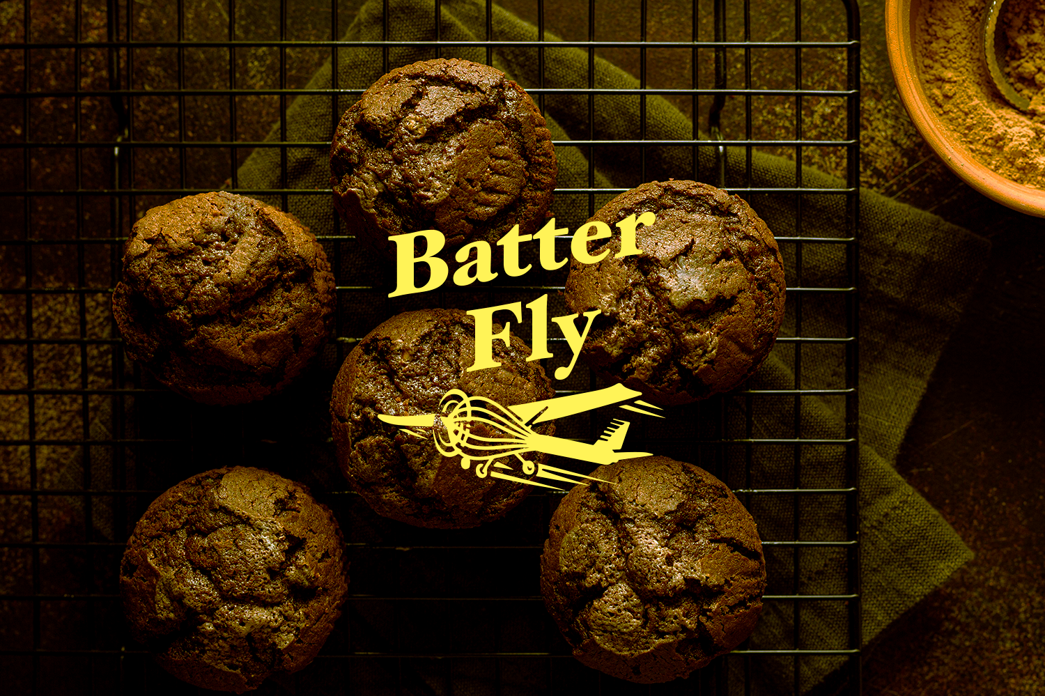 top-view-chocolate-muffins-cooling-rack-with-cocoa-powder
